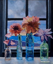 Four colored vases sit on the window sill of a beach house overlooking the ocean.