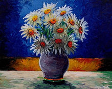 Vibrant bunch of white daises sit in a violet vase on a cloth covered table.