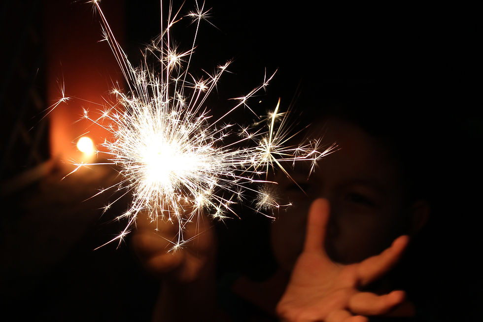 A lit sparkler gives off white light and sparks while a marketing wizard harnesses it's magic.