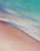 Turquoise ocean waters washing over pink sands
