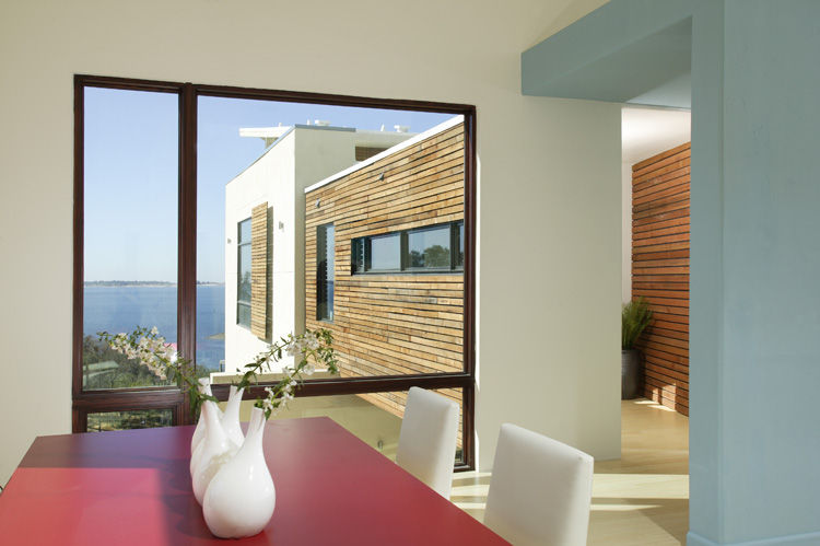 Southwest Florida construction project, interior living and dining space of a large modern home or mansion with large windows, a view of the ocean, and ceiling beams. 