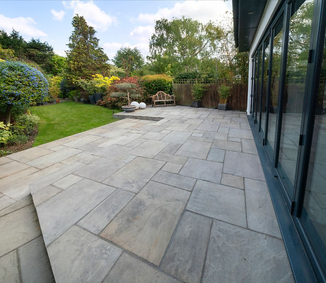 Beautiful indian sandstone patio with attractive garden and bifold doors