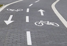 Straße, bemalt mit zweispurigem Fahrradweg, Fahrrad und Pfeil jeweils in die entgegengesetzte Richtung
