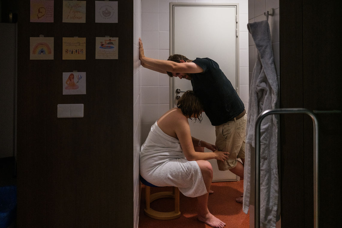 Mama vangt contracties op terwijl ze tegen papa steunt