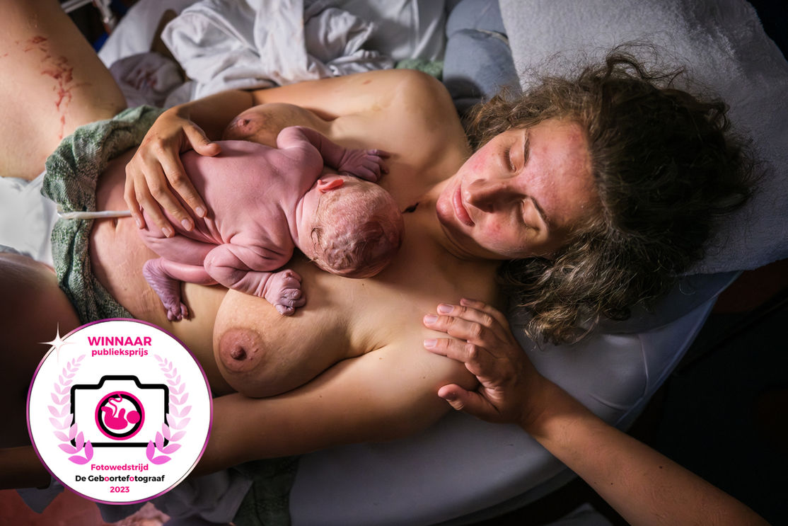 Publieksprijs fotowedstrijd geboortefotograaf hand op schouder mama met baby in kikkerhouding op de buik. 