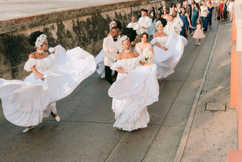 Novios bailando al ritmo de la musica y mulatas por las calles de Cartagena, Colombia