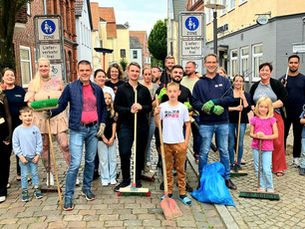 Oliver Schmidt-Gutzat mit Anwohnerinnen und Anwohnern bei der Gemeinschaftsaktion im Schuhmacherort in Heide: Müllsammeln und Putzen in der Straße.