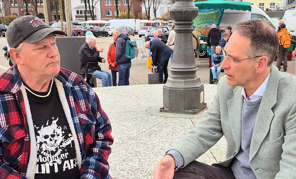Oliver Schmidt-Gutzat im Gespräch mit einem Mann auf dem Wochenmarkt in Heide