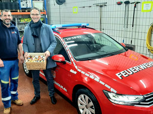 André Dithmer, Wehrführer der Freiwilligen Feuerwehr Süderholm, und Oliver Schmidt-Gutzatmit dem neuen Kommandowagen in der Fahrzeughalle der Feuerwehr.
