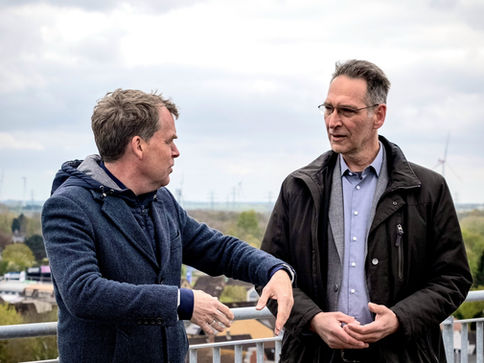 Ulf Kämpfer und Oliver Schmidt-Gutzat im Gespräch auf einer Dachterrasse mit Blick über Heide