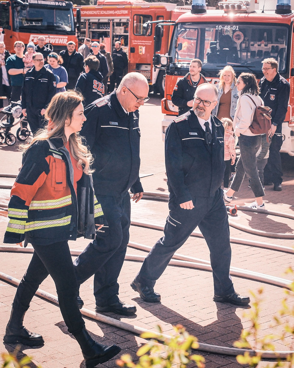 Innenministerin Magdalena Finke im Gespräch mit Feuerwehrangehörigen vor Einsatzfahrzeugen