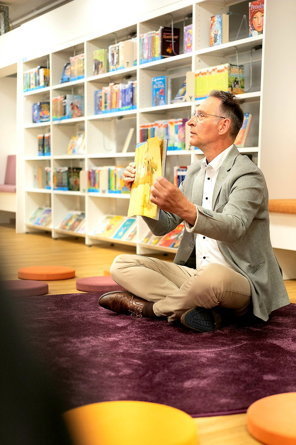 Oliver Schmidt-Gutzat liest bei einer Vorlesestunde im Rahmen der Kinderwoche in der Stadtbücherei Heide vor