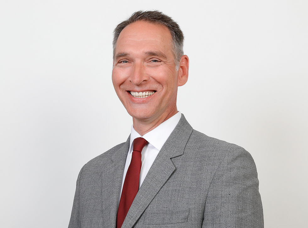 Porträt von Oliver Schmidt-Gutzat im grauen Anzug und roter Krawatte, offizielles Bewerbungsfoto für die Bürgermeisterwahl 2026 in Heide.