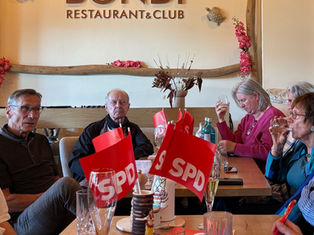 Dr. Axel-Michael Unger im Gespräch mit Bürgerinnen und Bürgern beim SPD-Bürgergespräch im Restaurant Bondi, SPD-Fähnchen auf dem Tisch.