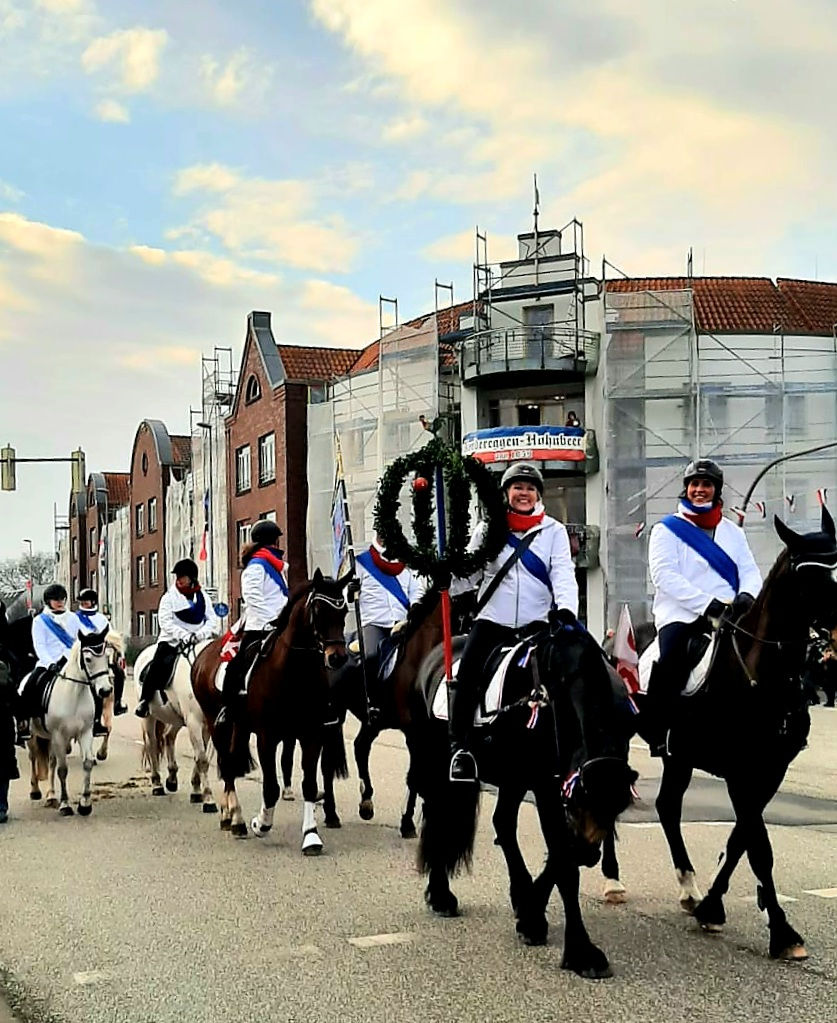 Ringreitergilde Süderholm-Bennewohld reitet mit geschmückten Pferden im Umzug durch die Innenstadt von Heide in Richtung Stadttheater.