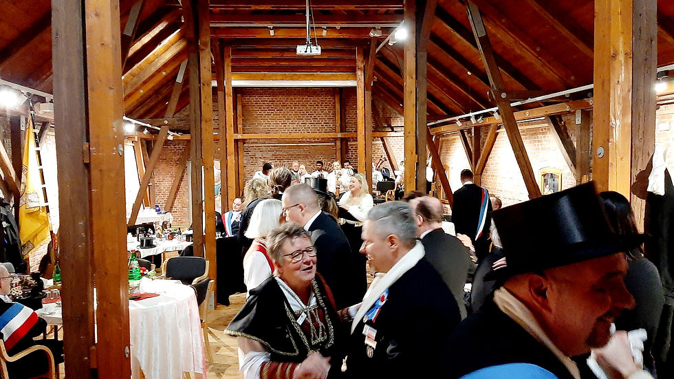 Feierliche Einkehr der Hohnbeergruppe auf der Museumsinsel in Heide, mit zahlreichen Gästen an langen Tafeln unter Holzbalken.