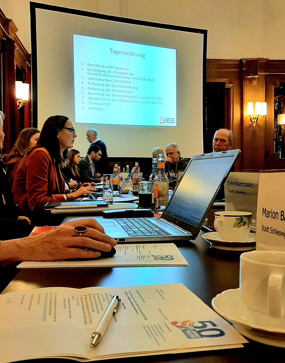Gesellschafterversammlung des Schleswig-Holsteinischen Landestheaters mit gezeigter Tagesordnung auf der Leinwand.