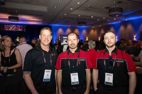 Three men posing for photo at the MASTER TECH EXPO event.