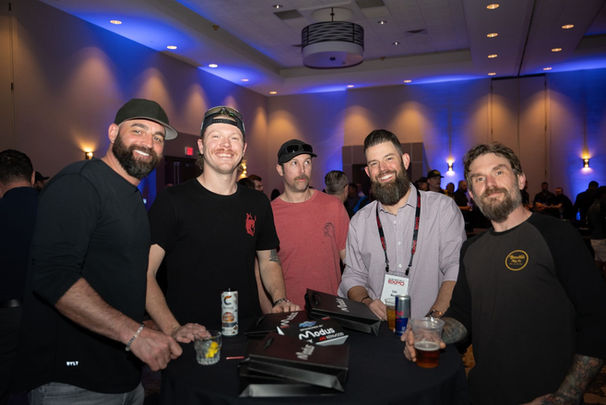 Five men smile around table at event during networking KICK-OFF PARTY.