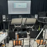 Audio setup with multiple speakers and a screen displaying a waveform.