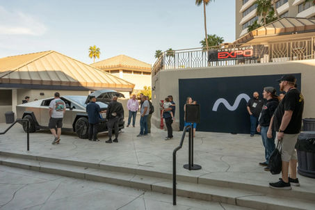 Cybertruck and group of people near a venue with