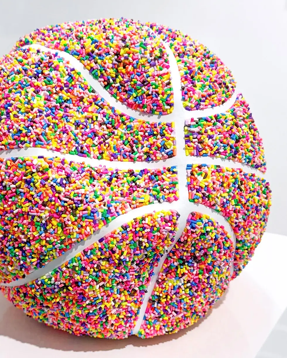 Original sprinkle pop art basketball sculpture by Peppy Colours displayed on a minimalist white pedestal.