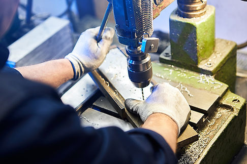 employee-drilling-aluminium-flat-steel-plate-with-bench-drill-metal-drill-bit-makes-holes-