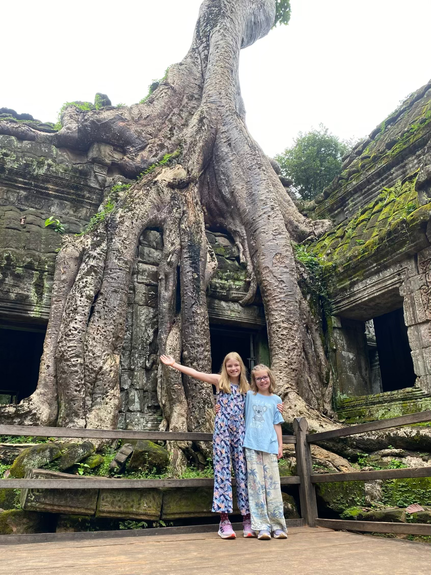 the girls in front of huge tree roots