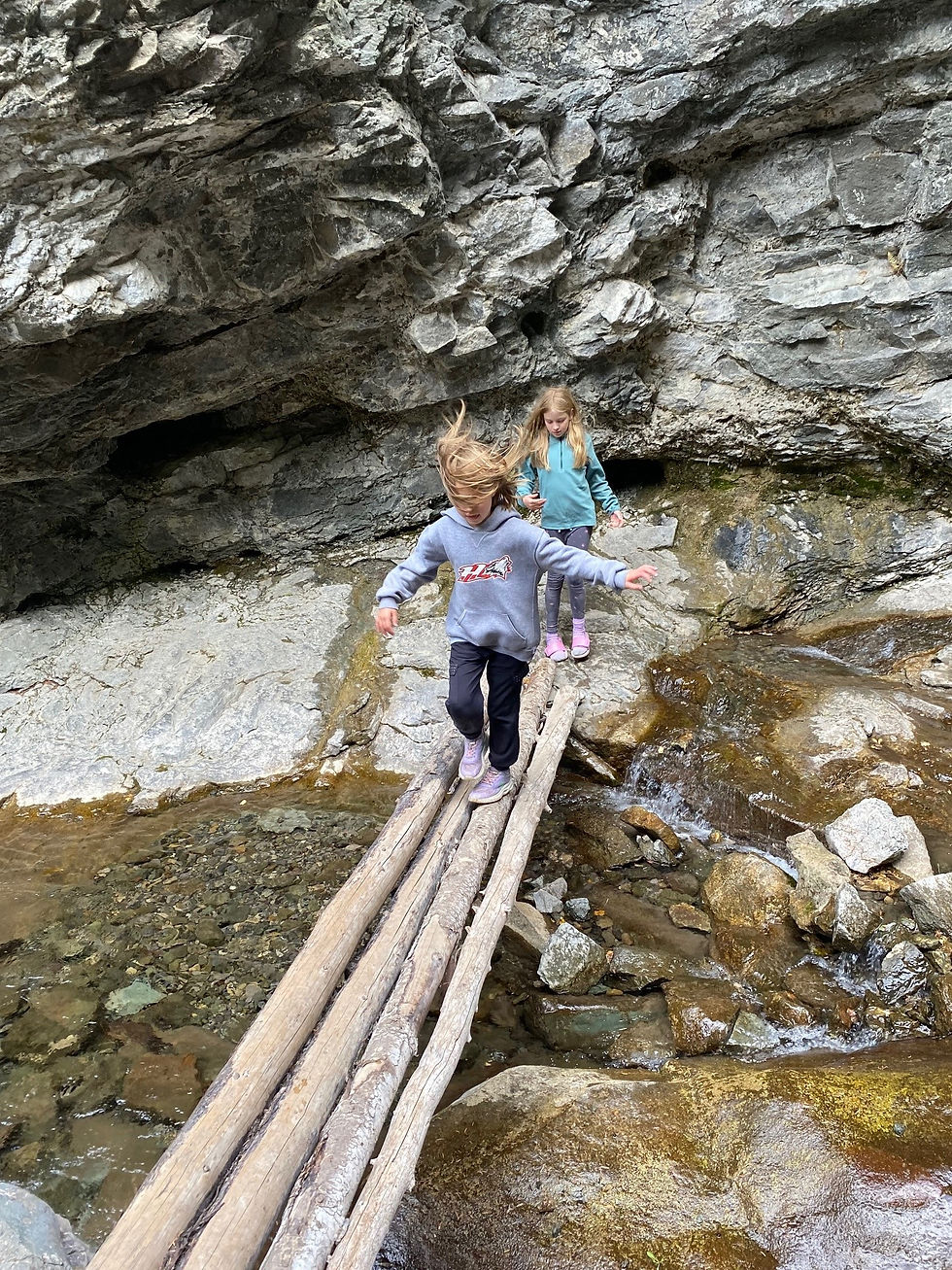 Our girls crossing a river via bridges made from logs