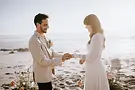 Bohemian bride and groom exchanging wedding rings on the Misty Cliffs beach in Cape Town