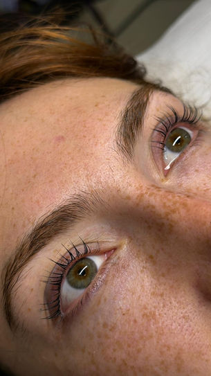 Close-up of defined brow shaping and tint on a woman's face.