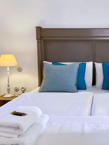 Vintage double bed in the Palomar Gran Canaria apartment, featuring white bed linen and blue pillows.