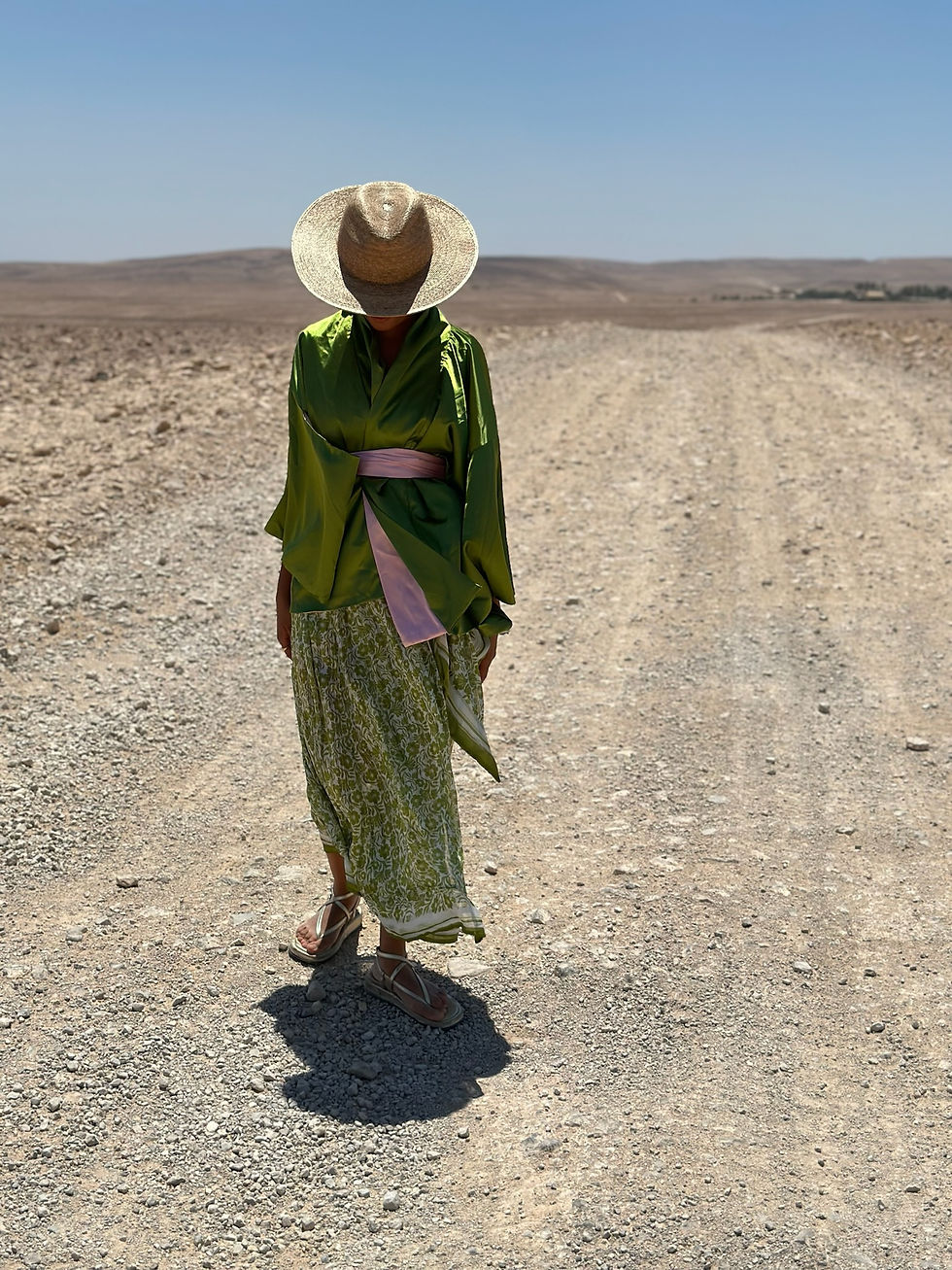 Thumbnail: אישה על שביל באמצע המדבר לובשת קימונו קצר בצבע ירוק עם חגורה ורוד בייבי