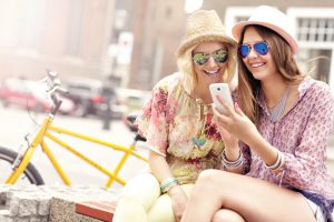 Two women enjoying a shared text. Avoid texting anythjng inflammatory or abusive, or even startlingly good news.