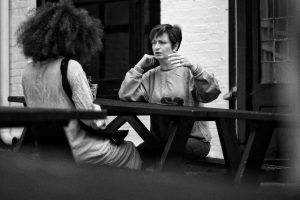 Hear me out! Two women in serious conversation on a balcony.