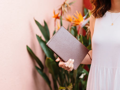 Close up of Hannah holding brown notebook