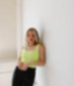 Girl in Yellow Tank top and Black Pants Leaning against wall