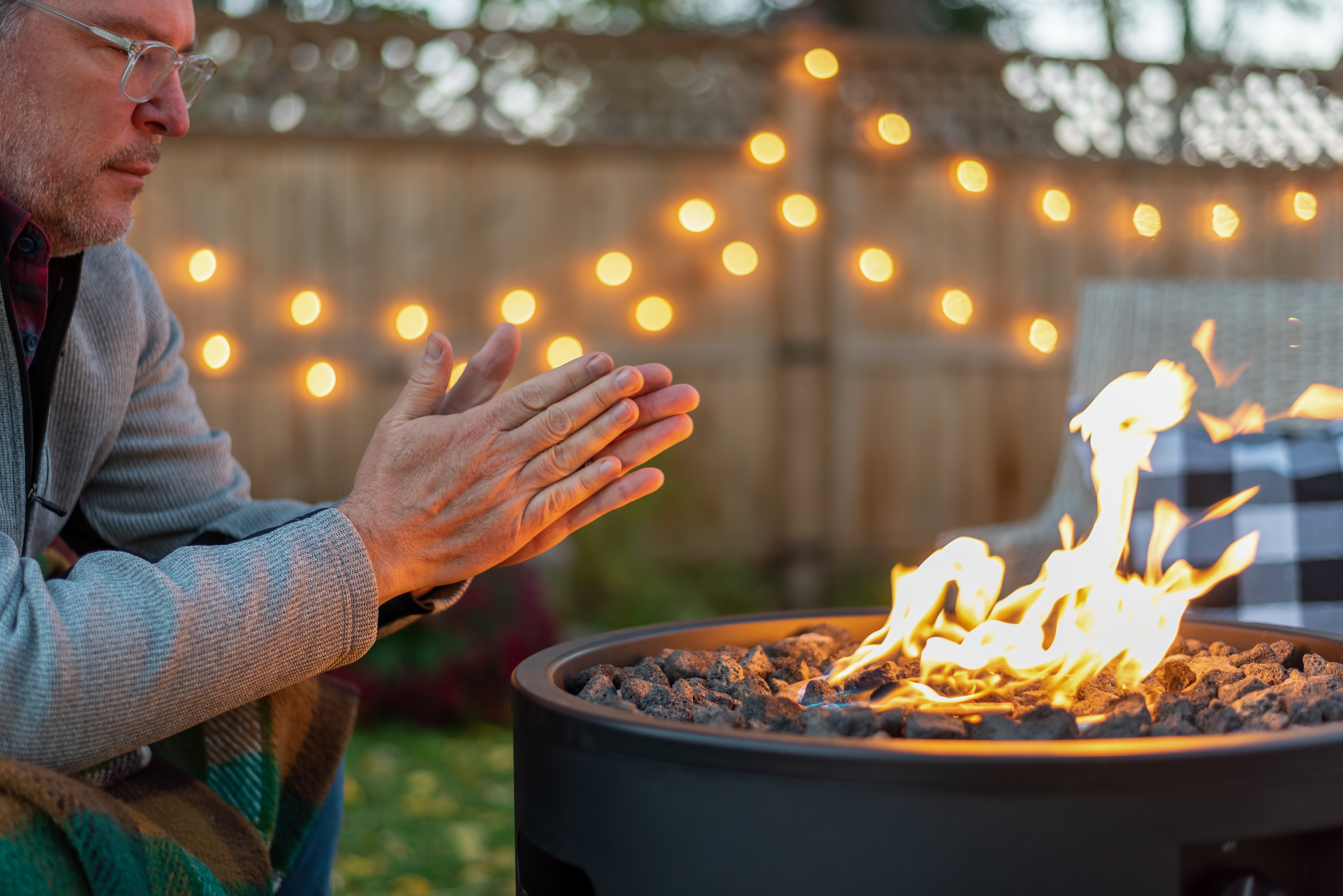 Man warming his hands by a fire at dusk.jpg