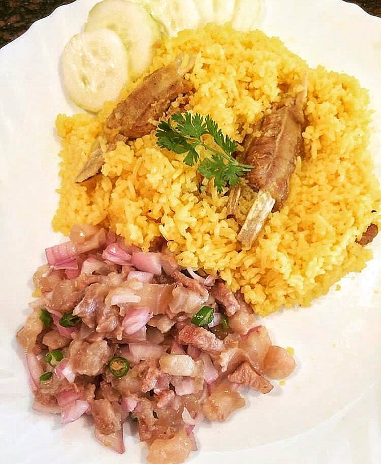 Jadoh Meghalaya pork and rice dish served in traditional bowl with aromatic herbs