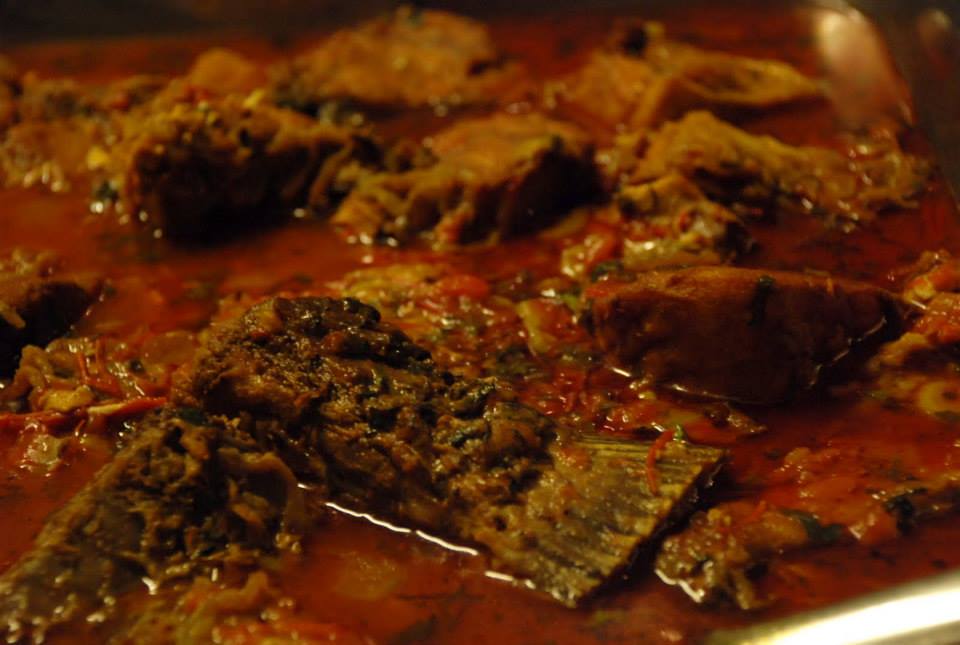 Masor Tenga Assamese fish curry in clay pot with tomatoes and traditional spices