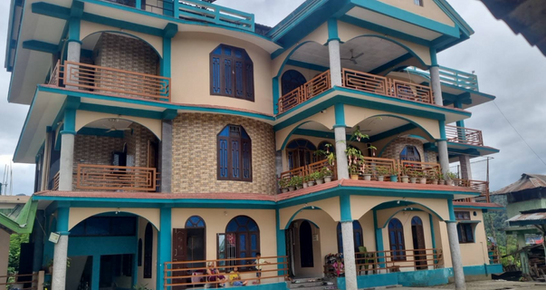 Front view of GT Homestay Aalo surrounded by greenery in Arunachal Pradesh