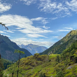 Panoramic view of Dibang Valley and Zawru Valley under a cloudy sky with sunlight breaking through.