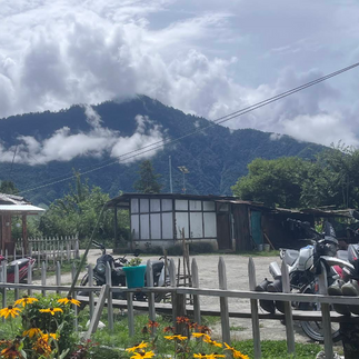 Cozy bamboo exterior of Kaji Lodge Anini, budget homestay in Dibang Valley with misty Himalayan hill