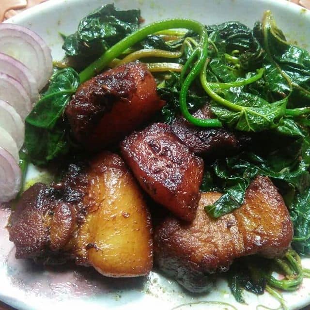 Vawksa Rep Mizoram smoked pork stir-fry with spinach and mushrooms on plate