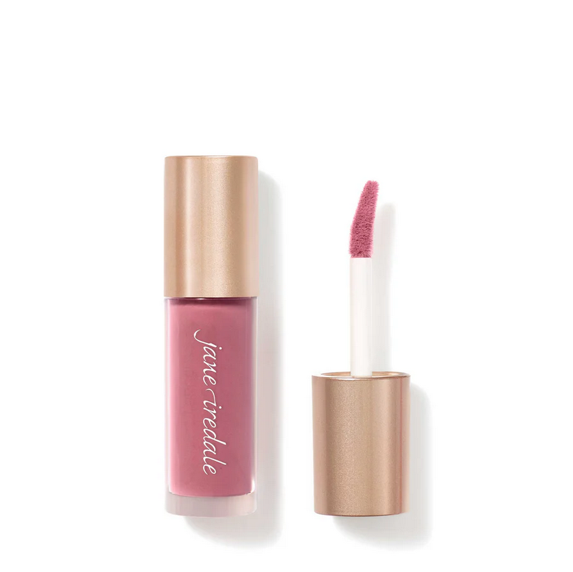 A clear bottle of makeup with a lip applicator.