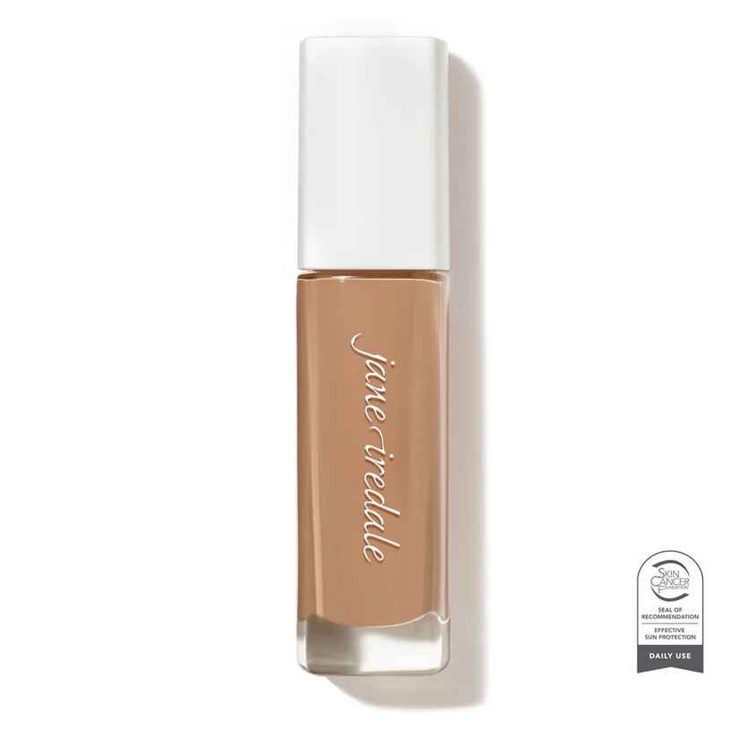 Clear glass make up bottle containing a medium shade of face foundation.