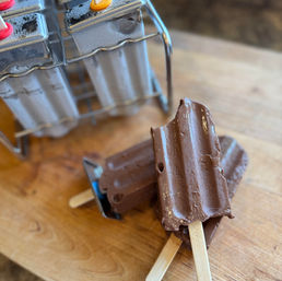 Homemade Fudgesicles on wooden cutting board