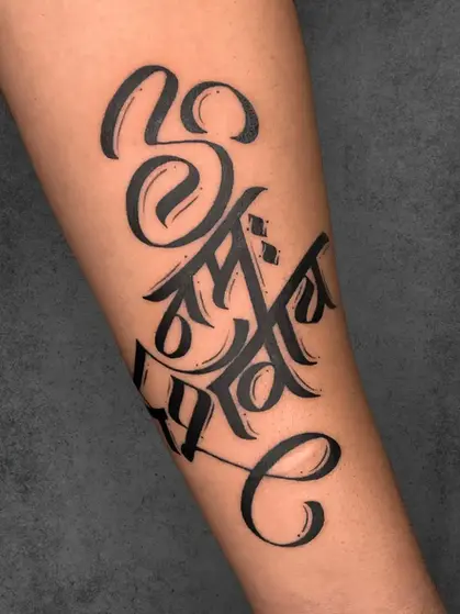 A striking tattoo featuring bold Sanskrit calligraphy in artistic strokes, embodying divine energy and power