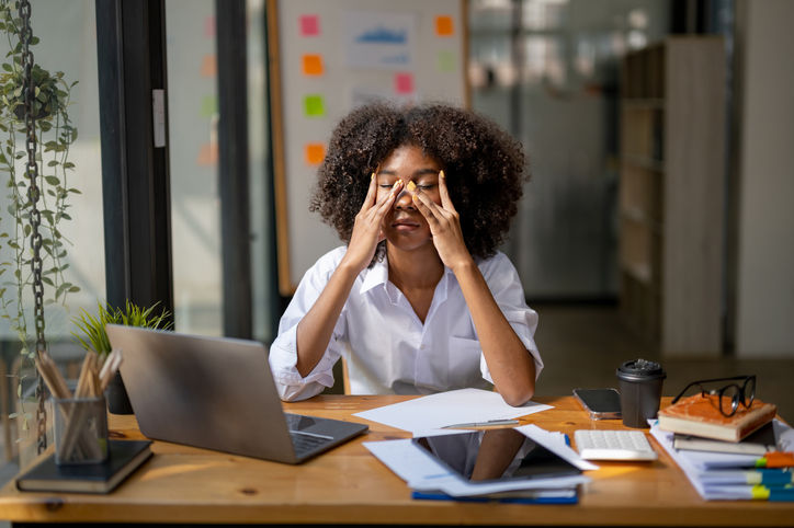 A person sitting at her desk looking tired