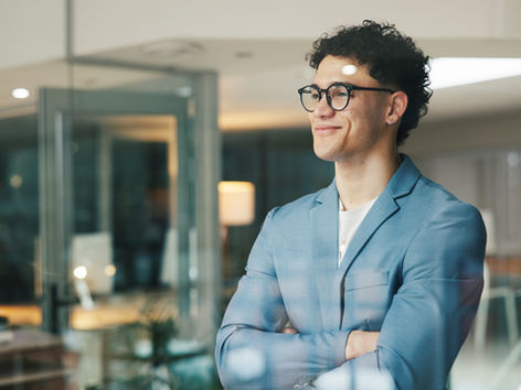 Young Business man looking through a pane glass smilling